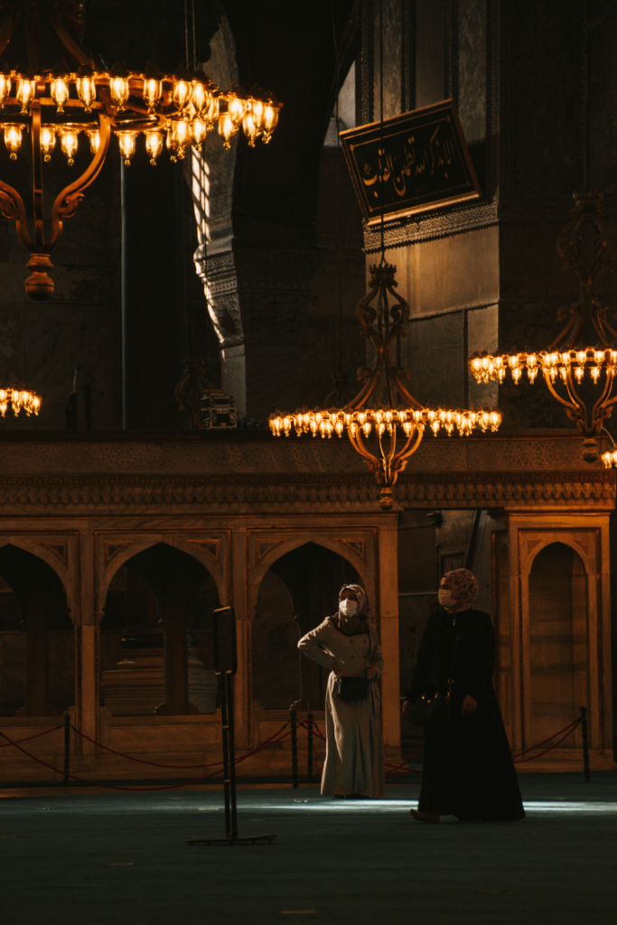 Opera house interior with chandelier, balconies, seating, and two opera singers performing on stage in full costume, used for a guide on how to prepare for your first opera